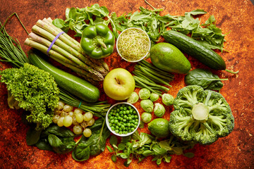 Fresh green vegetables and fruits assortment placed on a rusty metal