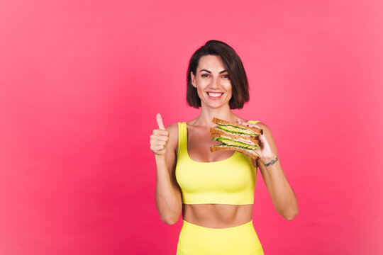 Beautiful Fit Woman In Yellow Bright Fitting Sportswear On Pink Background Happy Hold Healthy Avocado Sandwich