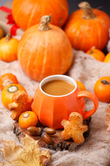 Cup of Pumpkin Spice Latte with Seasonal Autumn Spices, Gingerbread man Cookies and Fall Decor from fresh orange pumpkins. Traditional Coffee Drink for Autumn Holidays, cozy, hygge, comfortable