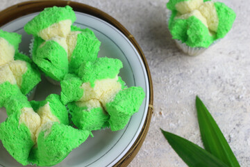 Bolu Kukus Pandan or Flower bloom steam cake, Indonesian traditional cake, with pandan leaves flavour. White bright background. Morning tea concept.