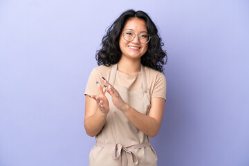 Restaurant asian waiter isolated on purple background applauding after presentation in a conference