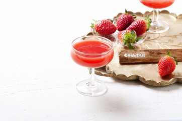Refreshing summer drink with strawberry in glasses on light background.