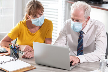 Obraz premium Businesspeople wearing protective medical mask in office during coronavirus outbreak