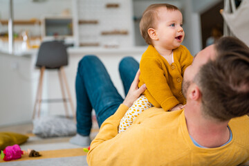Fototapeta premium Young father is having fun with his little baby