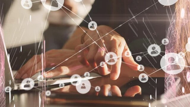 Animation of digital icons over woman using tablet and laptop