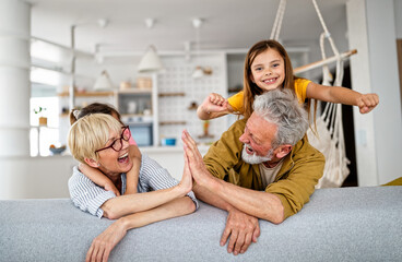 Happy grandparents having fun times with children at home