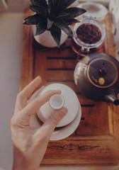 Chinese tea ceremony, girl pours pu-er from gaiwan through strainer in chahai, top view 