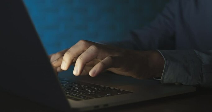 Hands of businessman typing on laptop computer keyword working at night 