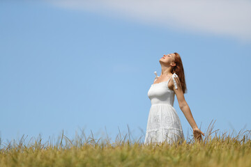 Fototapeta na wymiar Woman with white dress breathing fresh air in a wheat field