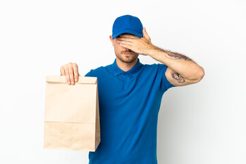 Brazilian taking a bag of takeaway food isolated on white background covering eyes by hands. Do not want to see something