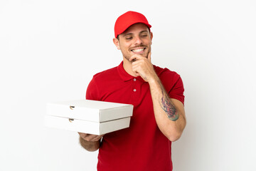 pizza delivery man with work uniform picking up pizza boxes over isolated  white wall looking to...
