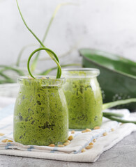 Homemade organic pesto sauce made from fresh arrows of garlic,dill and oil in a glass jar.