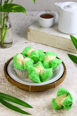 Bolu Kukus Pandan or Flower bloom steam cake, Indonesian traditional cake, with pandan leaves flavour. White bright background. Morning tea concept.