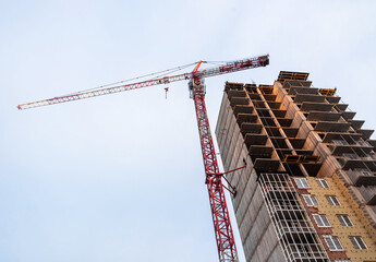 Naklejka premium Construction crane and high building skyscraper under construction