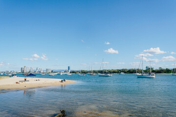 Fototapeta na wymiar People enjoy beach near Seaworld on the Gold Coast where yachts are moored