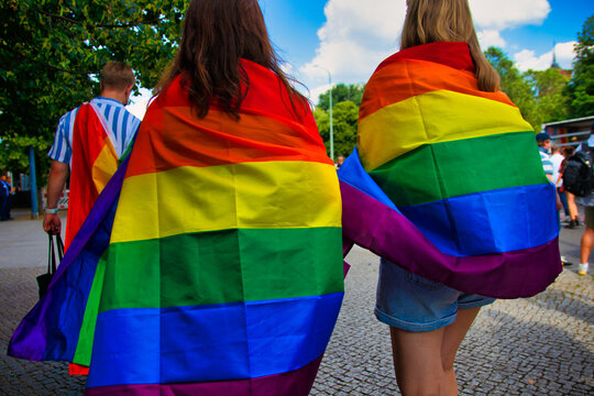 Two women carry a rainbow flag on Christopher Street Day (CSD)