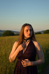 Teenage girl standing in a field in rural Germany on a warm spring night.