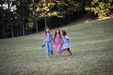 Fototapeta premium Three little girls walking trough nature together.