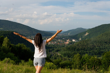 Fototapeta premium girl in the mountains enjoys the panorama of the mountains