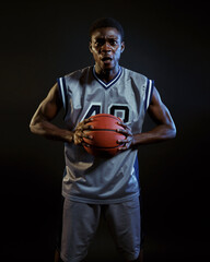 Aggressive basketball player poses with ball
