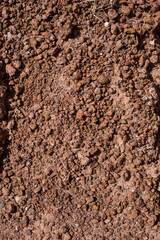 Cobbles background, granite wall. Small stones, Gravel. Sandy stones. Brown and orange. Light-brown stone , rock , gravel texture.