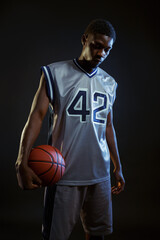 Aggressive basketball player poses with ball