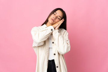 Teenager girl isolated on pink background making sleep gesture in dorable expression