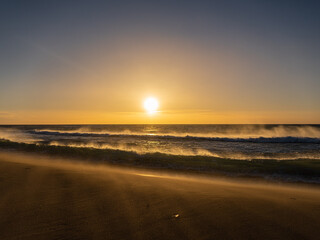 Fototapeta na wymiar Amanecer en la playa un dia de viento