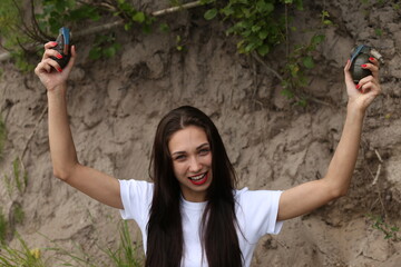Funny brunette woman with two grenades outside
