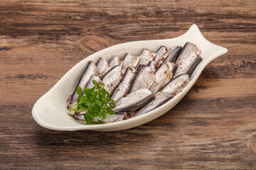 Anchovies in the bowl served basil leaves