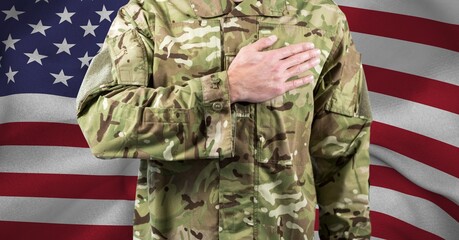 Composition of midsection of soldier with hand on heart, against american flag