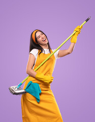 Cheerful female housekeeper having fun with broom in studio