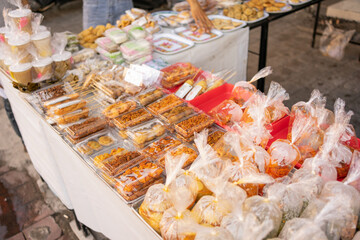 various kinds of traditional Indonesian street food, side dishes and vegetables wrapped in plastic on a serving plate on the table