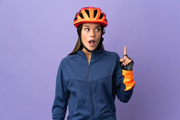 Teenager cyclist girl thinking an idea pointing the finger up