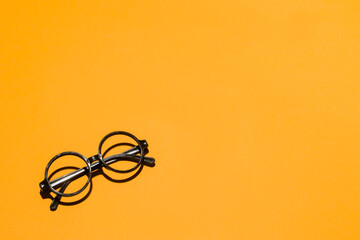 Glasses on orange studio background Copyspace

