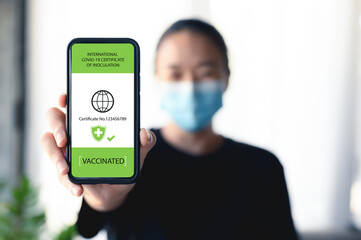 Vaccine passport, Close up hand of women with smartphone showing vaccination and health status proof that he has been immunized against COVID-19. Pandemic, new normal travel tourist concept.