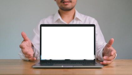 Cropped view Happy Asian man pointing showing with blank white screen of laptop computer. copy space. mock up computer screen.