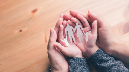 mother and baby hands holding paper family cutout, Happy family mother, father, children son and daughter.