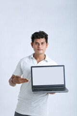 Young indian successful man showing laptop screen over white background.