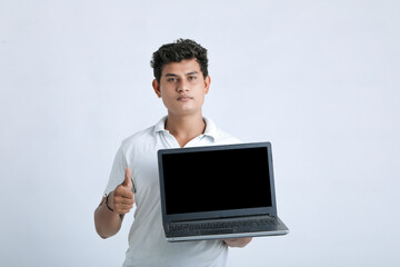 Young indian successful man showing laptop screen over white background.