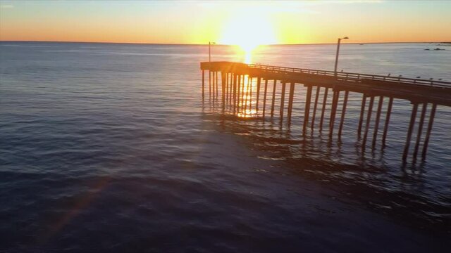 Aerial: Calm water at sunset at the beach. Pismo Beach