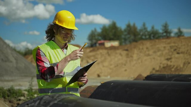 Building contractor counting number of pipes on the construction site.