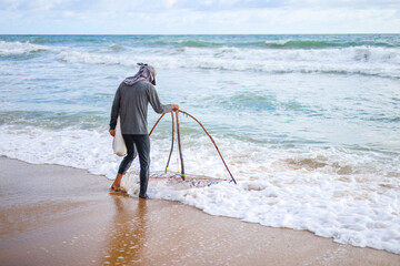 The fishermen casting at the Bang Hoi Beach, in the morning, Songkhla, Thailand.