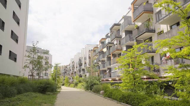 Rows of apartment buildings in a suburban apartment complex with a walkway and greenery