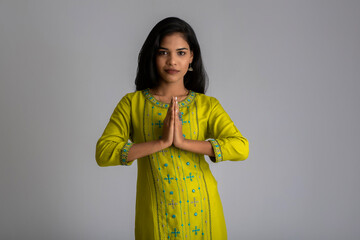 Beautiful Indian girl with welcome expression or inviting or greeting Namaste