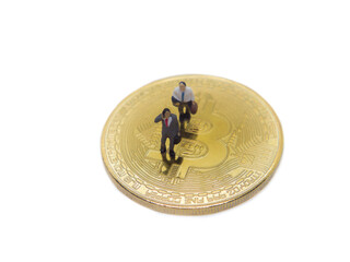 Miniature businessman walking on Golden coins of bitcoin cryptocurrency digital bit coin BTC currency on white background.