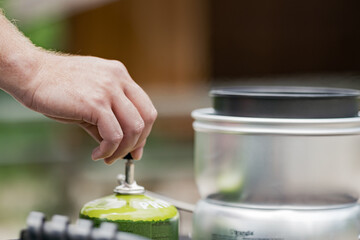 person preparing food in the wild on a gas trangia
