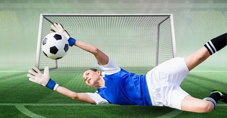 Composition of female goalkeeper catching ball at football stadium - Powered by Adobe