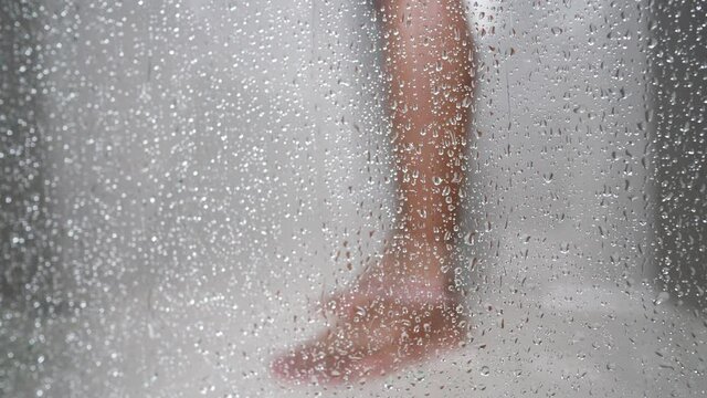 Close-up view of male leg taking shower at bathroom.	