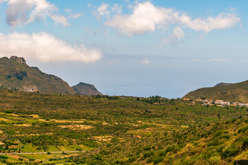 Fototapeta na wymiar Paisaje con montaña, vegetación y nubes de fondo en la isla de Tenerife